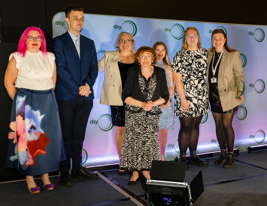 A group of people in formal clothes stood against a backdrop at the Disability Sport Yorkshire Awards
