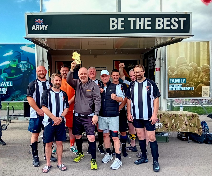 Marc and the NEL4Heroes holding up a trophy in their sports outfits