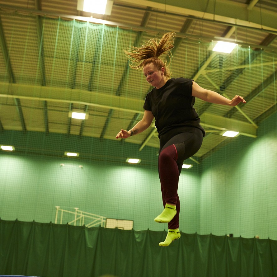Lady bouncing on a trampoline