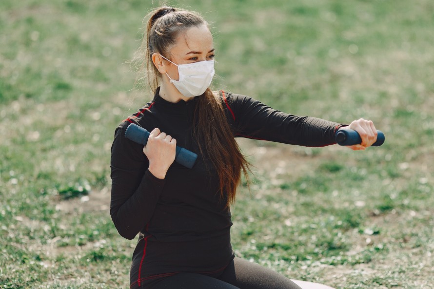 Woman exercising outdoors wearing face mask