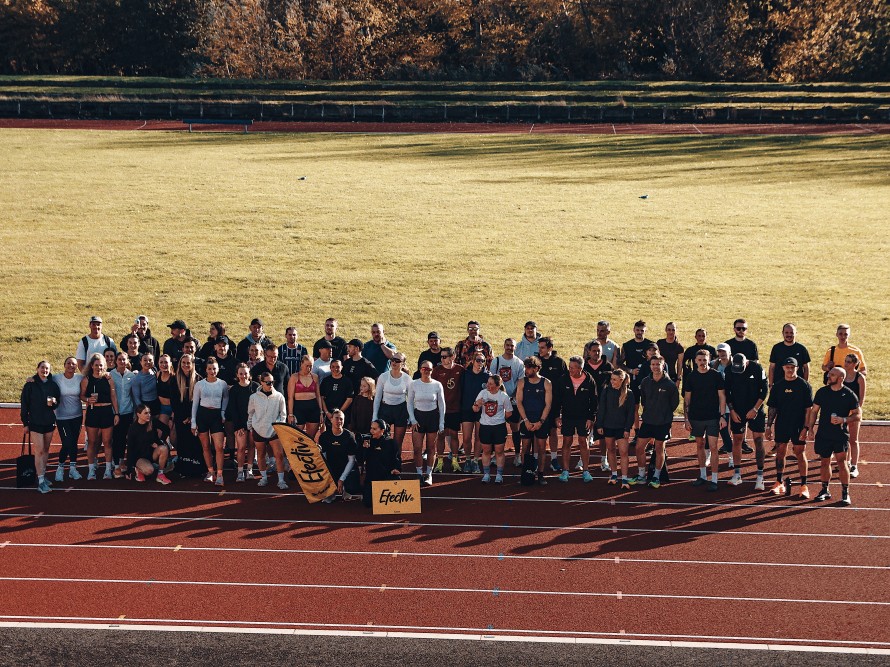 A large group of people stood on a running track in different outfits