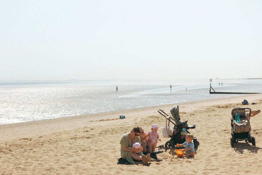 A mother with her children on Cleethorpes beach with the sea in the background